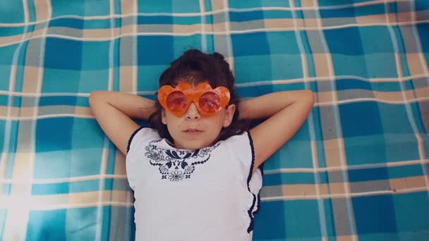 Komik Güneş Gözlüklü Piknik Battaniyesine Uzanmış Sakız Çiğneyen Ağır Çekimde — Stok video