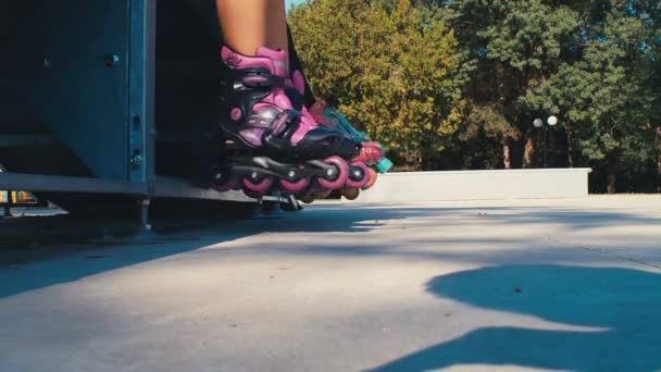 女の子子供の足とともにローラーブレードスケートで遊び場 4Kスローモーション — ストック動画