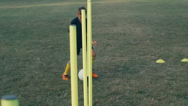 フィールド上のサッカーボールと子供の男の子のトレーニング 4Kスローモーション — ストック動画