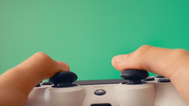 緑の画面と大きなフラットスクリーンの反対側のプレイヤーの手の中にゲームパッド — ストック動画