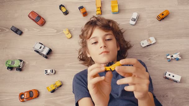 Bovenaanzicht Van Een Jarige Jongen Liggend Grond Spelend Met Speelgoedauto — Stockvideo