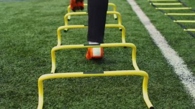 Futbol çeviklik eğitim ekipmanları. Antrenman engelli profesyonel futbolcu. 4k ağır çekim