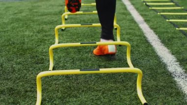 Futbol çeviklik eğitim ekipmanları. Antrenman engelli profesyonel futbolcu. 4k ağır çekim