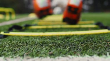 Futbol çeviklik eğitim ekipmanları. Çeviklik merdiveni olan profesyonel bir futbolcu. 4k ağır çekim