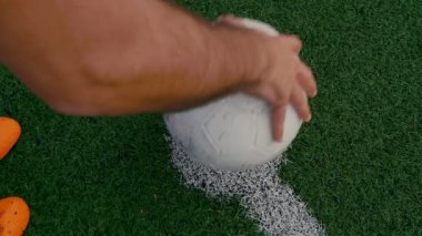 Futbolcu bir futbol sahasının ortasına bir top koyar. Sonra topa tekme attı. 4k ağır çekim