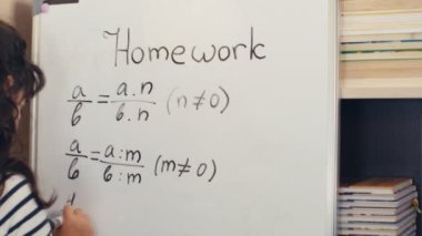 Evdeki beyaz tahtaya ödev yazan ve matematik okuyan bir kız, 4K
