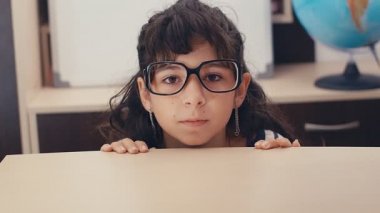 Kafkasyalı şirin bir kızın yüzüne düşen ödevlerle dolu kalın yığının komik bir sahnesi, 4K