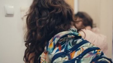 Bir kız veda ediyor, el sallıyor, kameraya bakıyor ve evden ayrılıyor. Hoşça kal okul, okula dön.