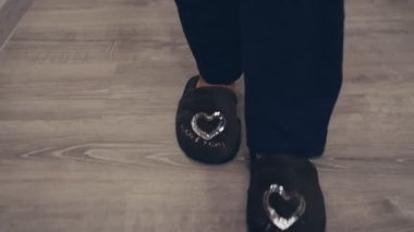 Evde rahat terlikler giyip kız ayaklarına yakın dur.