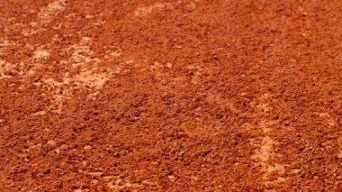 Toplar turuncu kil tenis kortunda zıplıyor.