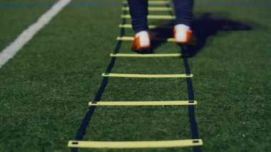 Futbol çeviklik eğitim ekipmanları. Geceleri çeviklik merdiveni olan profesyonel bir futbolcu. 4k ağır çekim