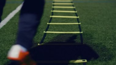 Futbol çeviklik eğitim ekipmanları. Geceleri çeviklik merdiveni olan profesyonel bir futbolcu. 4k