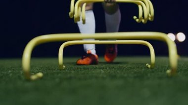 Futbolcu geceleri futbol çevikliği eğitim ekipmanları topluyor. 4k ağır çekim