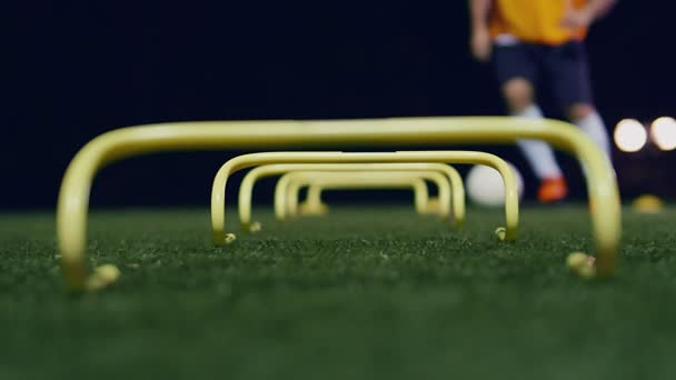 Fußballer Mit Ball Inmitten Von Agility Trainingsgeräten Der Nacht Zeitlupe — Stockvideo