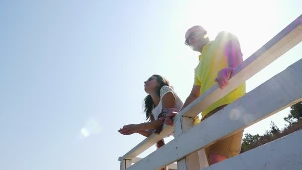 低角度海のビーチを見下ろす白い階段で若いカップル スローモーション — ストック動画
