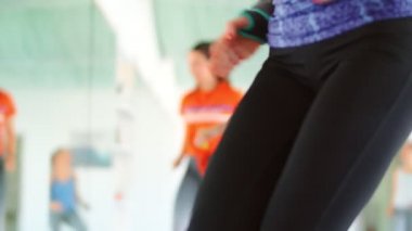 Dans fitness sınıfı Zumba dans eden güzel kadınlar koreografi hareketlerinden zevk alıyorlar bir spor salonunda bir eğitmenle, 4k ağır çekim