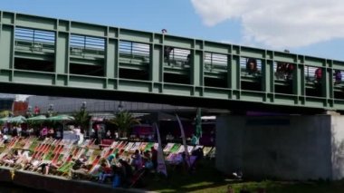 Berlin 'deki Spree nehrinin yanındaki açık hava barında oturan insanlar, 4K