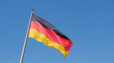 Alman bayrağı mavi gökyüzünde dalgalanıyor, 4K