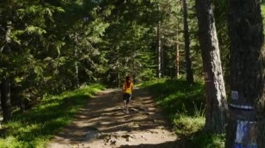 Dağın tepesinde koşan bir kadının kamerasını izliyoruz.