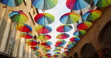 Şehir caddesinin üzerinde gökyüzünde renkli şemsiyeler açık. Dekorasyon olarak, 4K