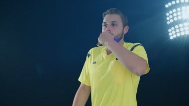 Siyah arka planda futbol hakemi VAR Video Yardımcı Hakem 'i elleri ile 4k ağır çekimde gösteriyor.