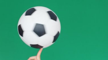 Düşük açılı futbol topu görüntüsü bir parmak üzerinde dönüyor, yeşil ekran arka plan, 4k yavaş çekim
