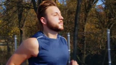 Stadyumda koşan genç bir adamın kamera görüntüsü, 4 km yavaş çekim.