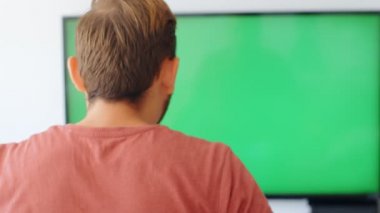 Sports Fan Reaction Concept - Kızgın ve hayal kırıklığına uğramış bir taraftarın arka planda favori takım / oyuncusunu evinde, yeşil ekranda izleyen 4k yavaş çekim