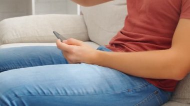 Sports Fan Reaction Concept - Heyecanlı bir spor fanatiği favori takım / oyuncusunu evinde akıllı telefondan izliyor, 4K ağır çekim