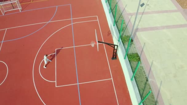 Drónfelvétel Egy Srácról Aki Kosárlabda Mozdulatait Góljait Gyakorolja — Stock videók