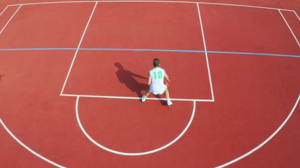 Drónfelvétel Egy Srácról Aki Kosárlabda Mozdulatait Góljait Gyakorolja — Stock videók