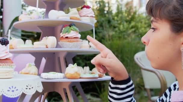 Een Meisje Kiest Heerlijke Cupcakes Een Buffet Een Kinderfeestje — Stockvideo