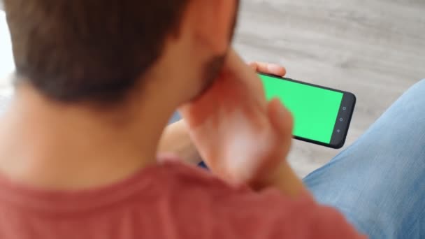 运动迷反应概念 兴奋的运动迷在家里用绿色屏幕的智能手机观看他最喜欢的团队 4K慢动作 — 图库视频影像
