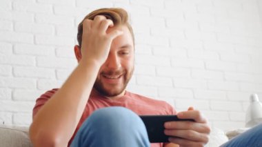 Sports Fan Reaction Concept - Heyecanlı bir spor fanatiği favori takım / oyuncusunu evinde akıllı telefondan izliyor, 4K ağır çekim