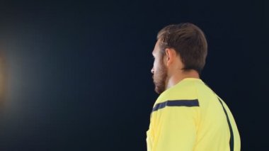 Siyah arka planda futbol hakemi kırmızı kart gösteriyor, 4k ağır çekim.