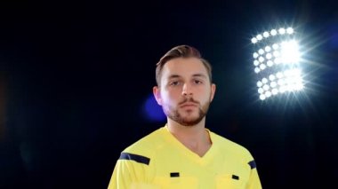 Siyah arka planda futbol hakemi penaltı sarı kartını gösteriyor, 4k ağır çekim.