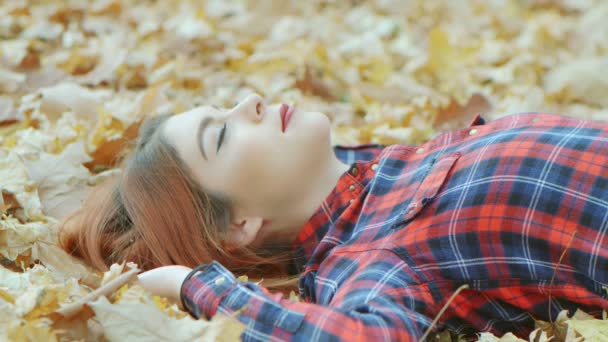 黄色い紅葉の中に赤い髪の美しい女性の肖像画 人生を楽しむ女性モデルアウトドア自然背景4Kスローモーション — ストック動画