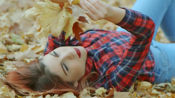 Retrato Uma Mulher Bonita Com Cabelo Vermelho Deitado Folhas Outono — Vídeo de Stock