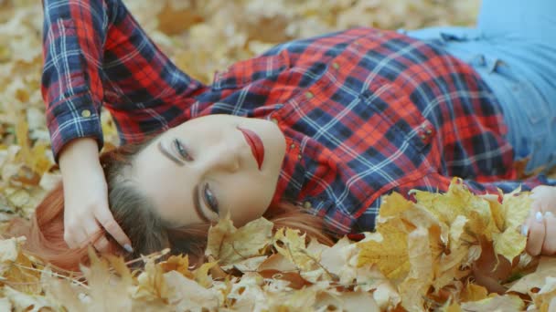 Retrato Uma Mulher Bonita Com Cabelo Vermelho Deitado Folhas Outono — Vídeo de Stock