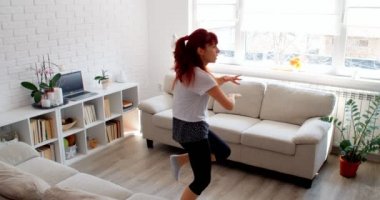COVID-19 kavramı. Karantina sırasında evde tek başına spor yapan bir kadın. 4k