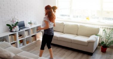 COVID-19 kavramı. Karantina sırasında evde tek başına spor yapan bir kadın. 4k