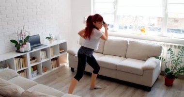 COVID-19 kavramı. Karantina sırasında evde tek başına spor yapan bir kadın. 4k