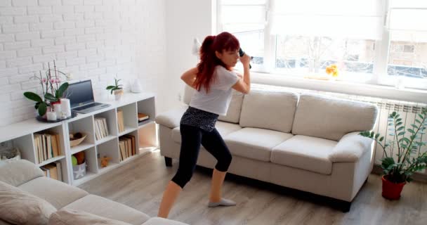 Covid 19のコンセプト 隔離中に一人で家でスポーツをしている女性 — ストック動画