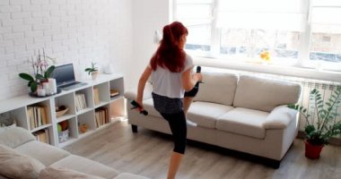 COVID-19 kavramı. Karantina sırasında evde tek başına spor yapan bir kadın. 4k