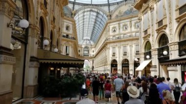 MILAN, ITALY 7-15-2019: Milano 'daki Galleria Vittorio Emanuele II' deki insanlar. 1875 yılında inşa edilen bu galeri Milano 'daki en popüler alışveriş merkezlerinden biridir. 4k