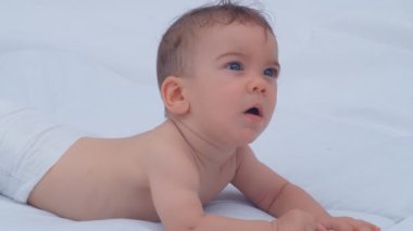 6 aylık oğlan etrafa bakıp gülümsüyor. Çocuklarla ilgilenme ve ebeveyn sevgisi kavramı, 4k ağır çekim