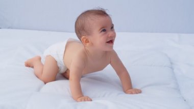6 aylık oğlan etrafa bakıp gülümsüyor. Çocuklarla ilgilenme ve ebeveyn sevgisi kavramı, 4k ağır çekim