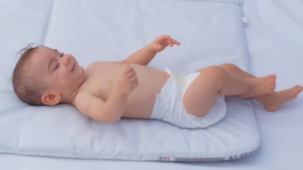 6ヶ月の赤ちゃんの男の子が周りを見て笑顔 子供や親の愛の世話の概念 4Kスローモーション — ストック動画