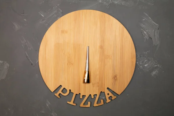 Round wooden tray on a gray background with yellow eyeliner