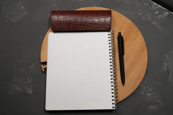 Notebook on a gray background and a tray